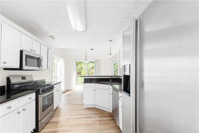 a kitchen with stainless steel appliances a stove a sink and a refrigerator