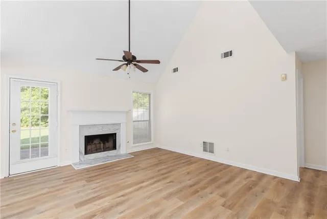a view of empty room with wooden floor and fireplace