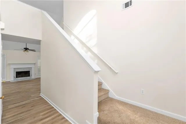 a view of a livingroom with wooden floor and staircase