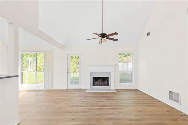 a view of an empty room with a fireplace and a window