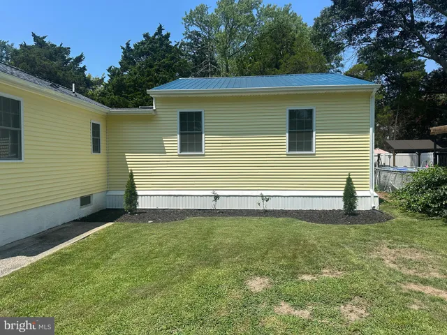 a view of a house with backyard and a tree