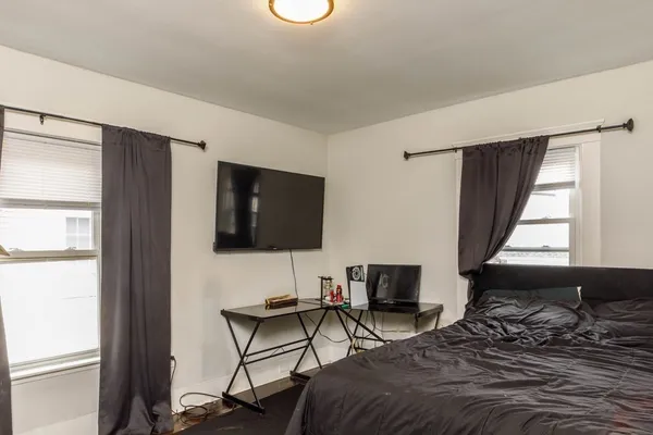 a bedroom with a bed and flat screen tv