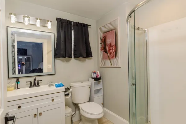 a bathroom with a toilet a sink and a mirror