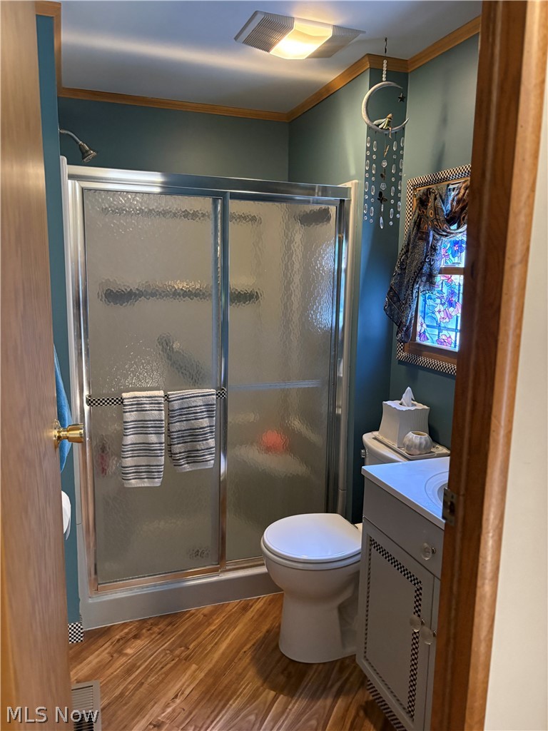 8701 Mayfield Road, Unit 148 Chesterland, OH 44026 - Photo 17 of 24 Bathroom featuring a shower with sliding glass doors, white toilet, single-basin vanity, and wood-finish flooring