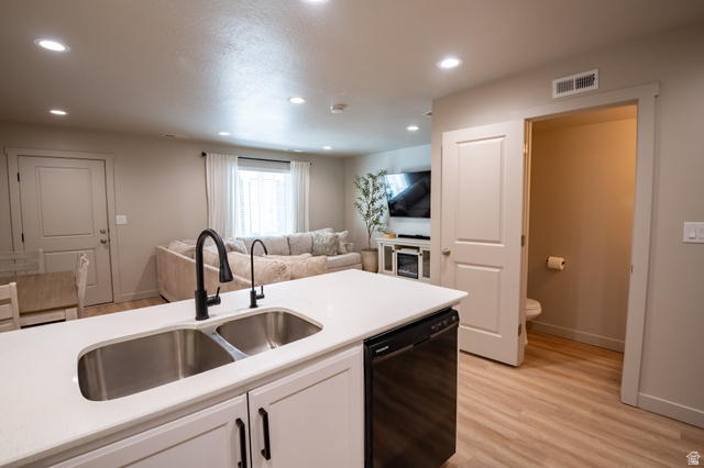 1787 North 1280 East Payson, UT 84651 - Photo 7 of 22 Kitchen island featuring a double basin stainless steel sink with matte black fixtures, white countertop, and integrated dishwasher