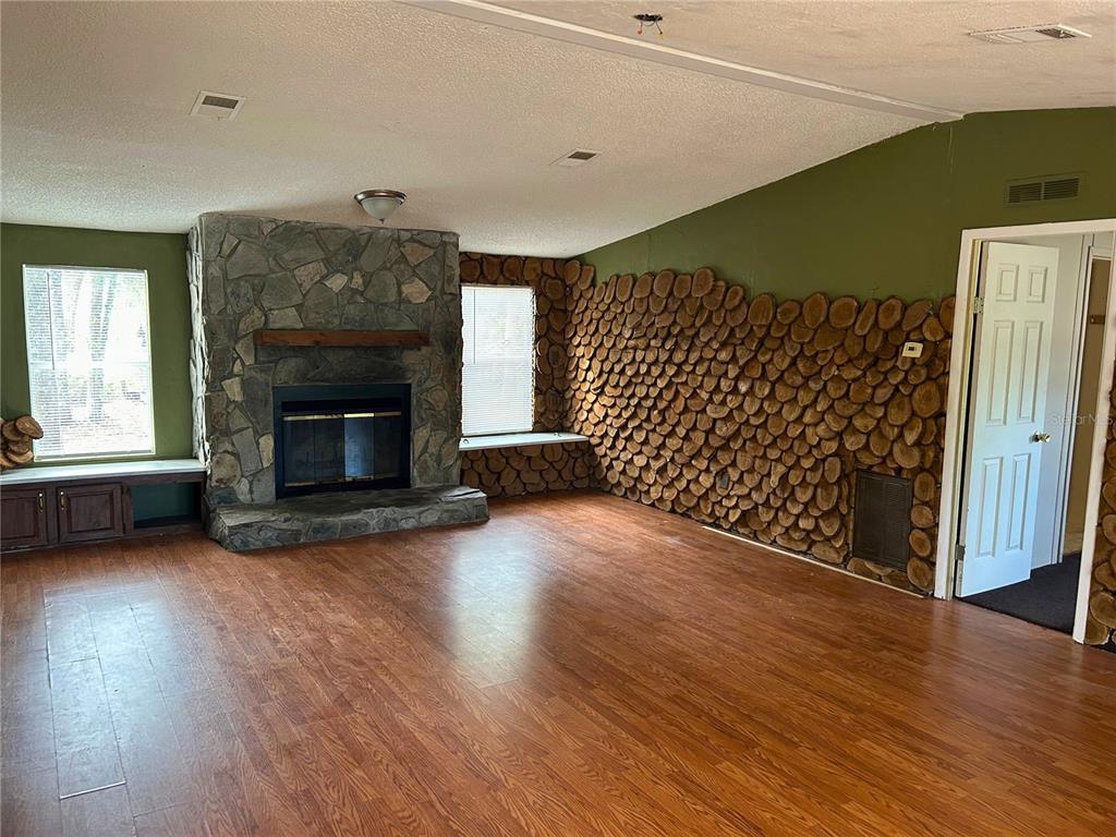 9867 Jerome Drive New Port Richey, FL 34654 - Photo 7 of 30 a view of empty room with wooden floor and fireplace