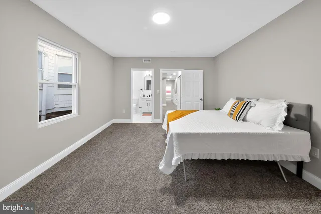 a spacious bedroom with a bed and window