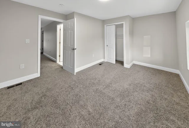 an empty room with windows and closet