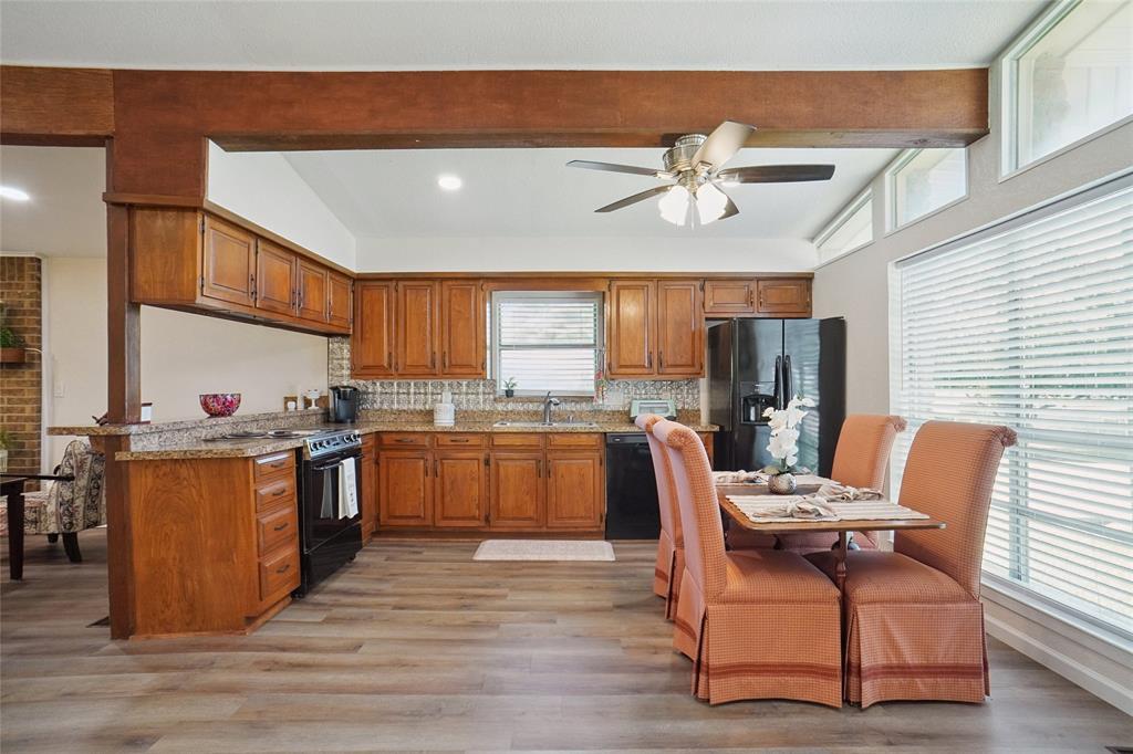 308 Half Moon Way Runaway Bay, TX 76426 - Photo 13 of 40 a kitchen with stainless steel appliances granite countertop a kitchen island a stove a sink a dining table and chairs