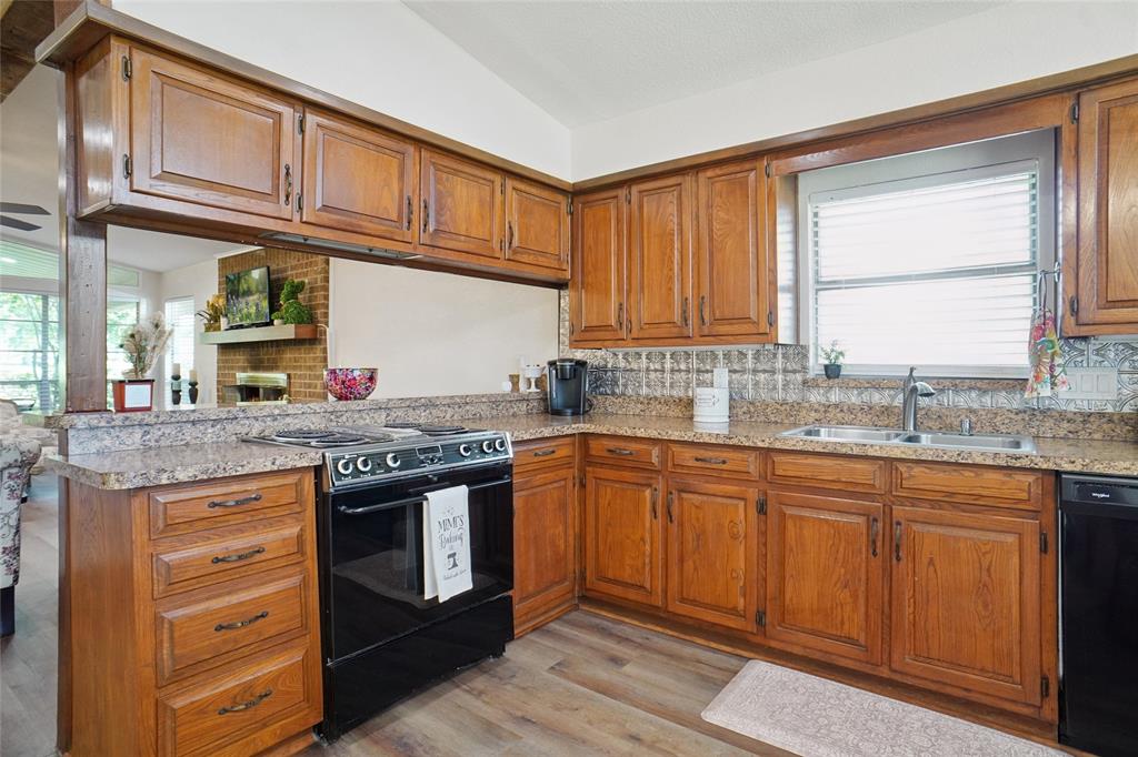 308 Half Moon Way Runaway Bay, TX 76426 - Photo 14 of 40 a kitchen with stainless steel appliances granite countertop a stove and a sink