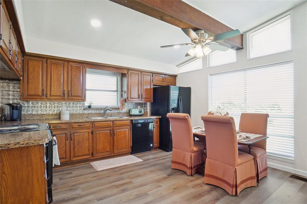 308 Half Moon Way Runaway Bay, TX 76426 - Photo 15 of 40 a kitchen with stainless steel appliances granite countertop a refrigerator a sink dishwasher a stove and white countertops with wooden floor