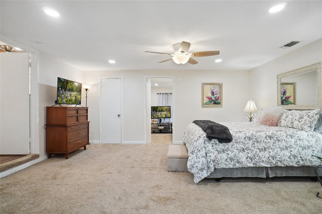 308 Half Moon Way Runaway Bay, TX 76426 - Photo 17 of 40 a spacious bedroom with a bed and a chandelier