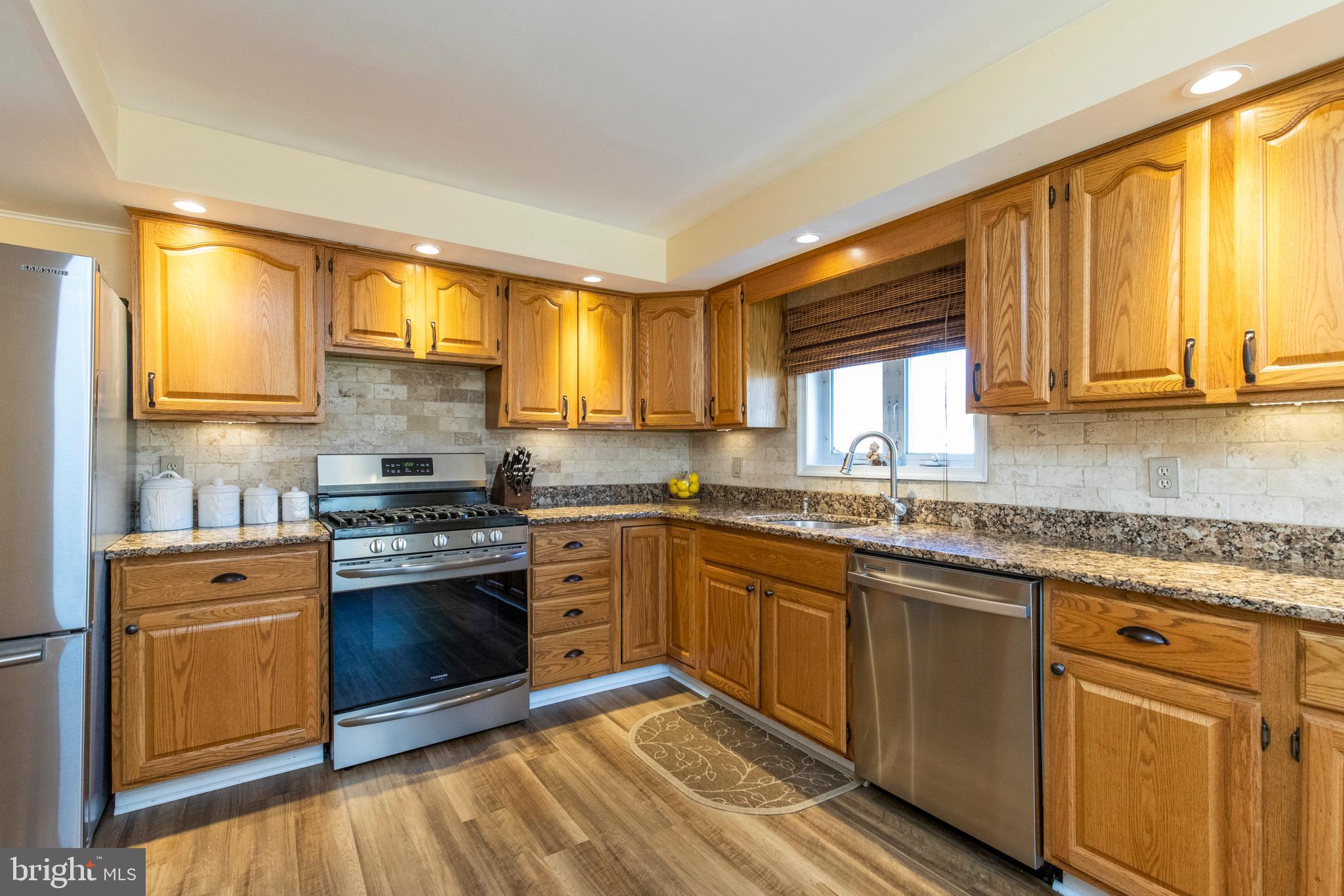 514 Maplewood Road Springfield, PA 19064 - Photo 14 of 38 a kitchen with stainless steel appliances granite countertop a stove a sink and a microwave
