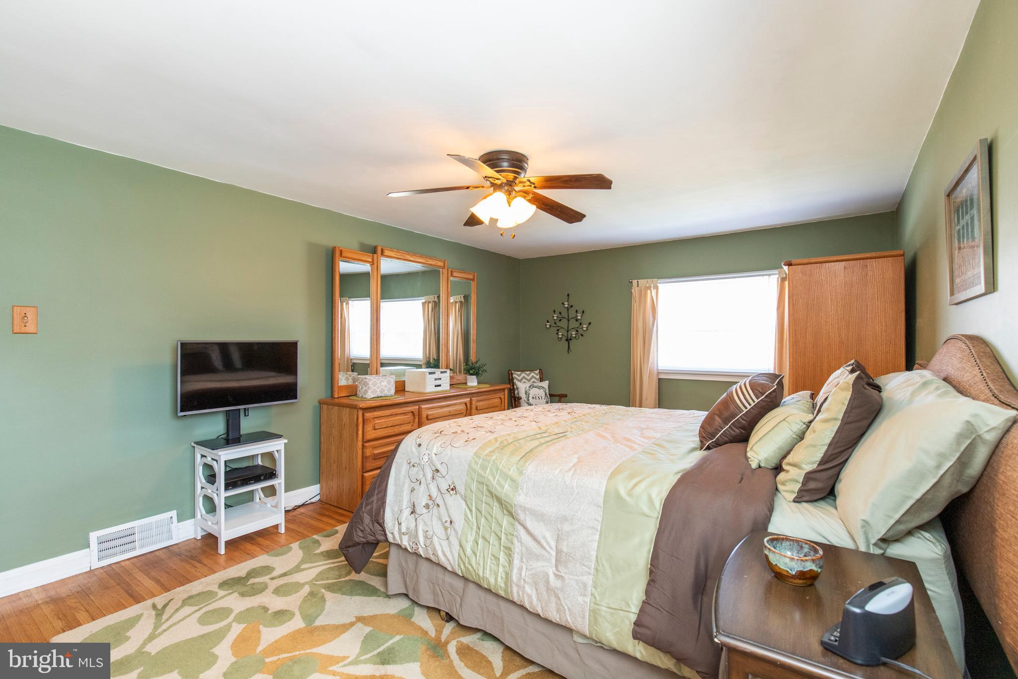 514 Maplewood Road Springfield, PA 19064 - Photo 22 of 38 a bedroom with a bed and a chandelier with a flat tv screen