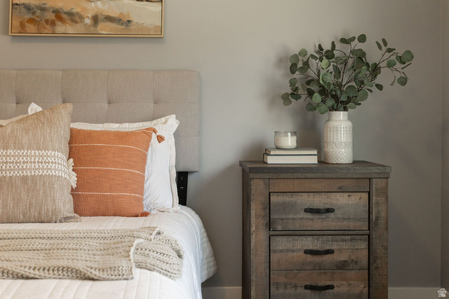 2483 South 1296th Street West Logan, UT 84321 - Photo 27 of 45 Upholstered, tufted headboard complementing a distressed wood-finish nightstand with dark hardware
