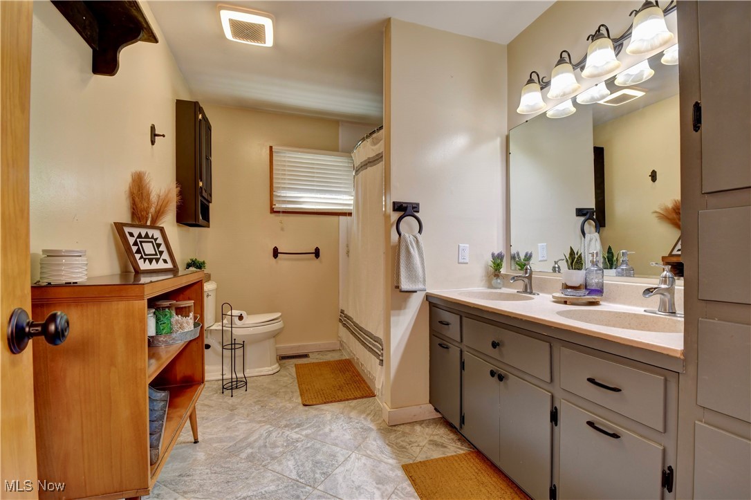 15235 Stocker Ridge Road Southwest Newcomerstown, OH 43832 - Photo 26 of 37 Bathroom featuring toilet, vanity, and tile patterned floors