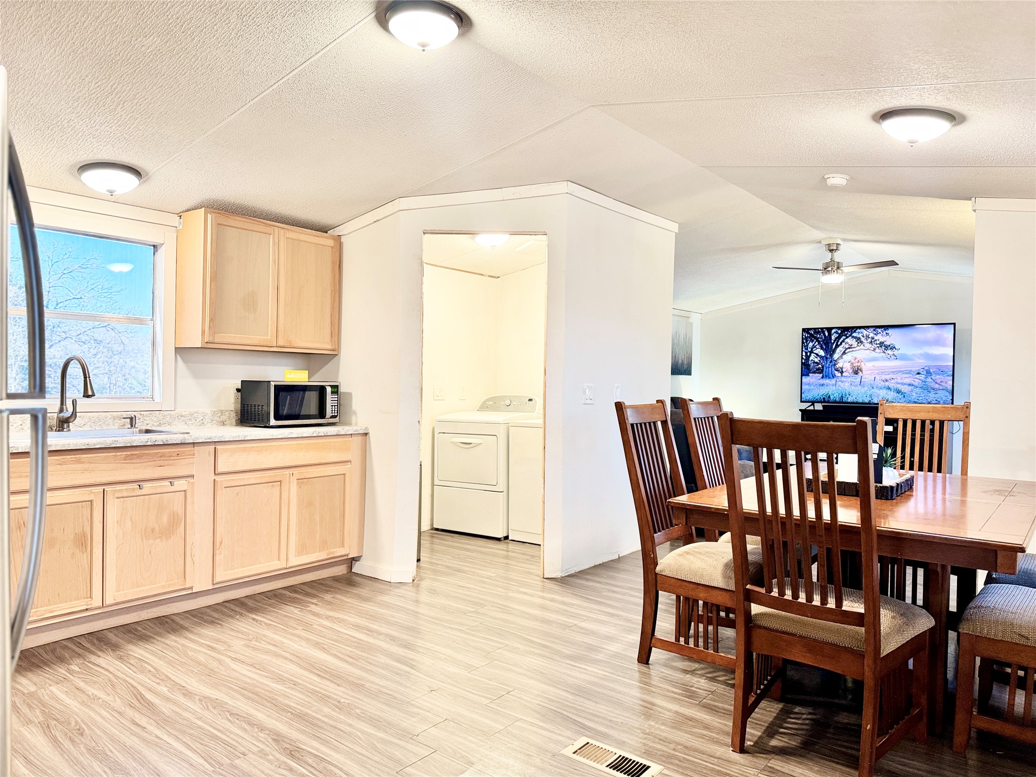 6739 Taylorsville Road Dale, TX 78616 - Photo 13 of 37 a kitchen with a dining table chairs and white cabinets