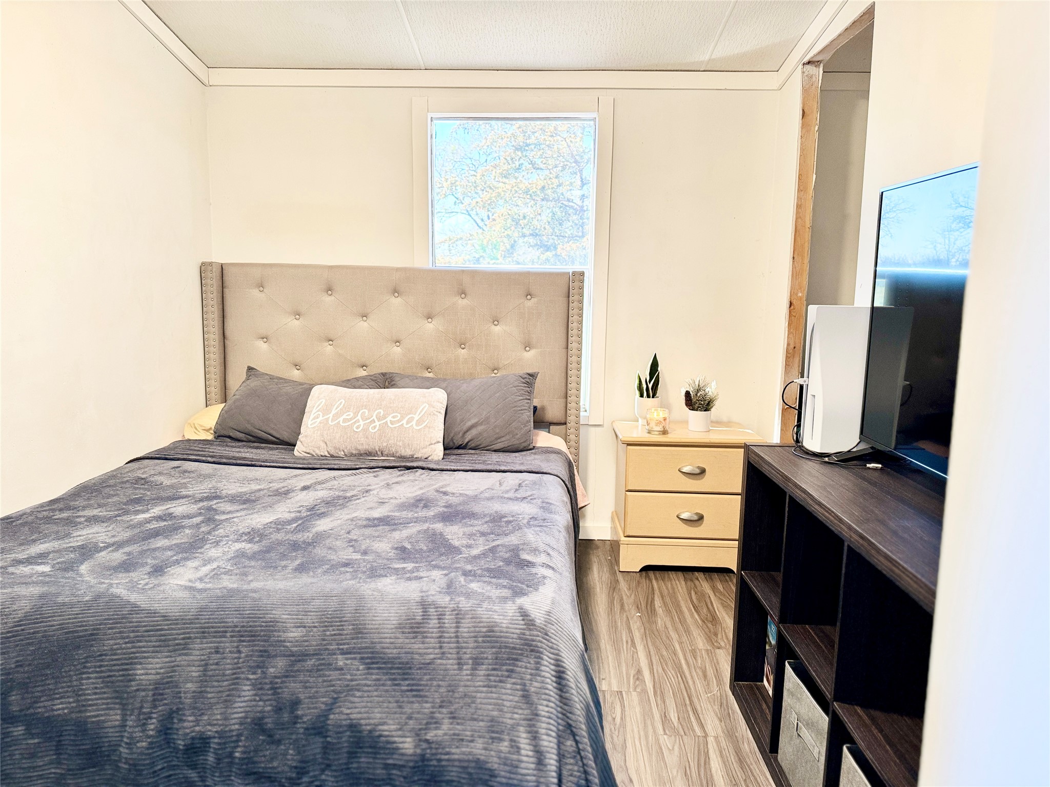 6739 Taylorsville Road Dale, TX 78616 - Photo 21 of 37 a bedroom with a bed and a flat tv screen on dresser