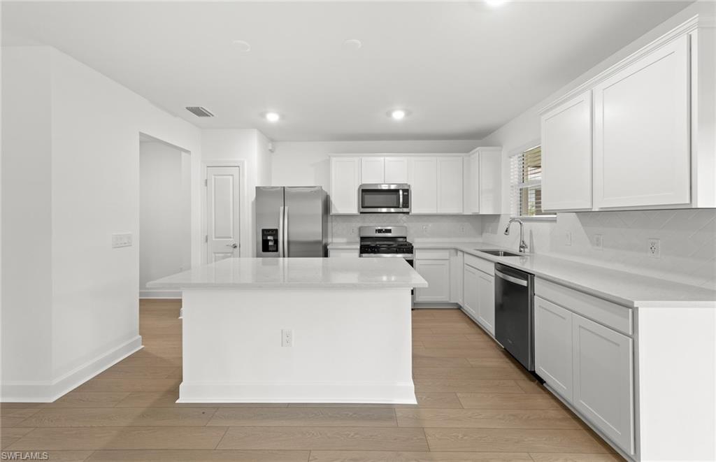 15827 Northridge Road Punta Gorda, FL 33982 - Photo 4 of 27 a kitchen with stainless steel appliances granite countertop a stove top oven a sink and white cabinets