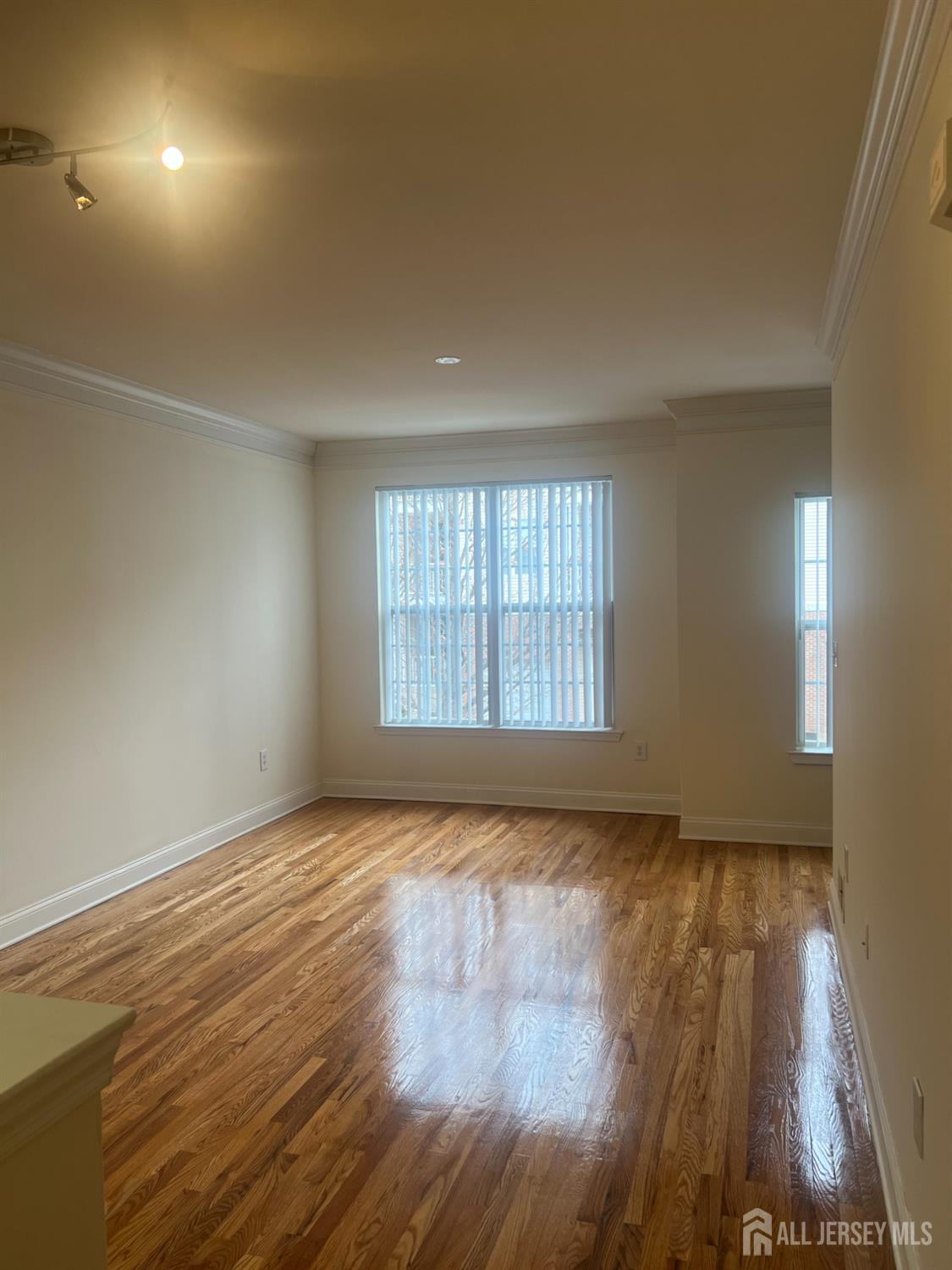 17 Burdak Road Sayreville, NJ 08859 - Photo 4 of 19 an empty room with wooden floor and windows