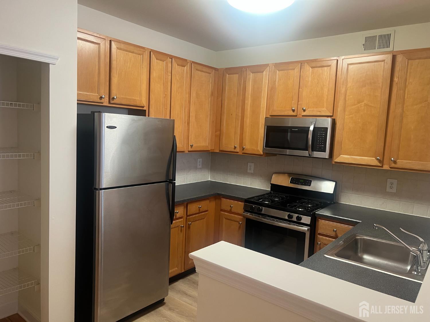 17 Burdak Road Sayreville, NJ 08859 - Photo 5 of 19 a white refrigerator freezer sitting in a kitchen