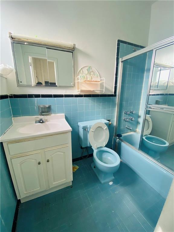 2308 Bath Avenue Brooklyn, NY 11214 - Photo 7 of 14 a bathroom with a sink a mirror and a toilet