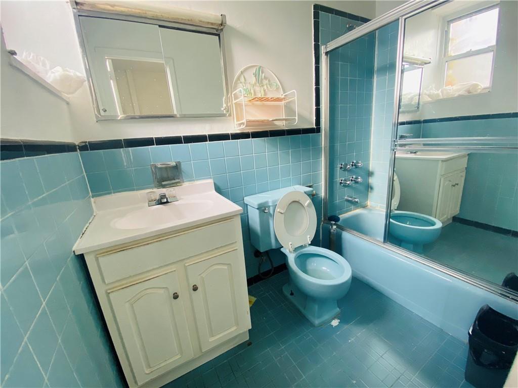 2308 Bath Avenue Brooklyn, NY 11214 - Photo 8 of 14 a bathroom with a sink toilet and mirror