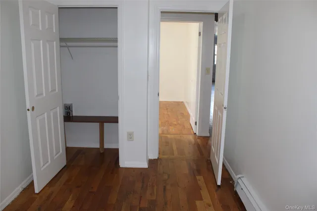 a view of a hallway with wooden floor and closet