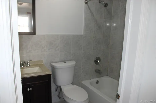 a bathroom with a bathtub shower sink vanity and toilet