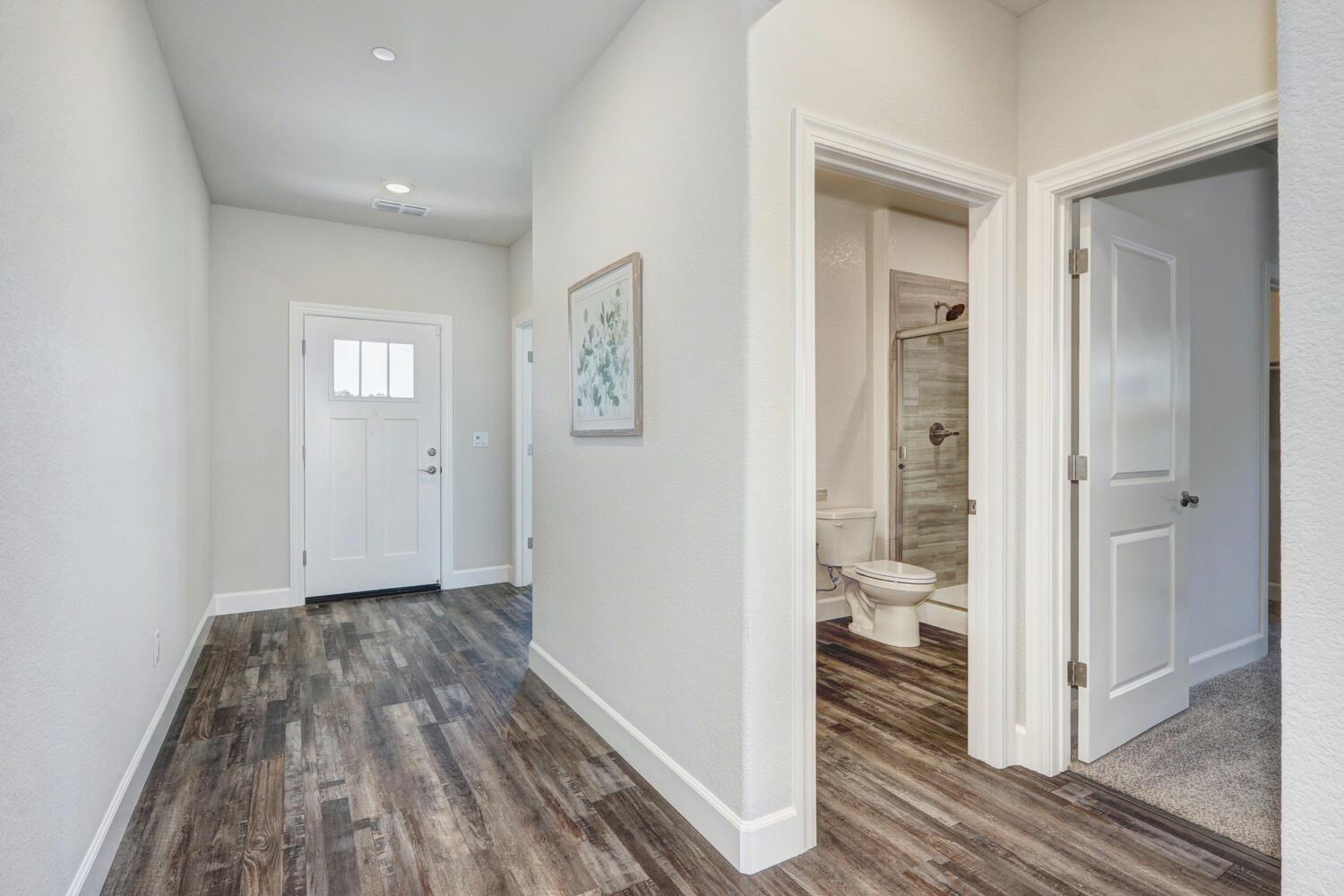 937 Norman Road Galt, CA 95632 - Photo 5 of 15 a view of a hallway with wooden floor and a bathroom