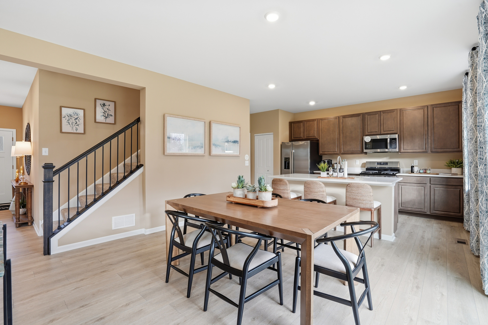 3859 Meadowridge Road Woodstock, IL 60098 - Photo 6 of 20 a kitchen with stainless steel appliances kitchen island granite countertop a dining table chairs and a refrigerator
