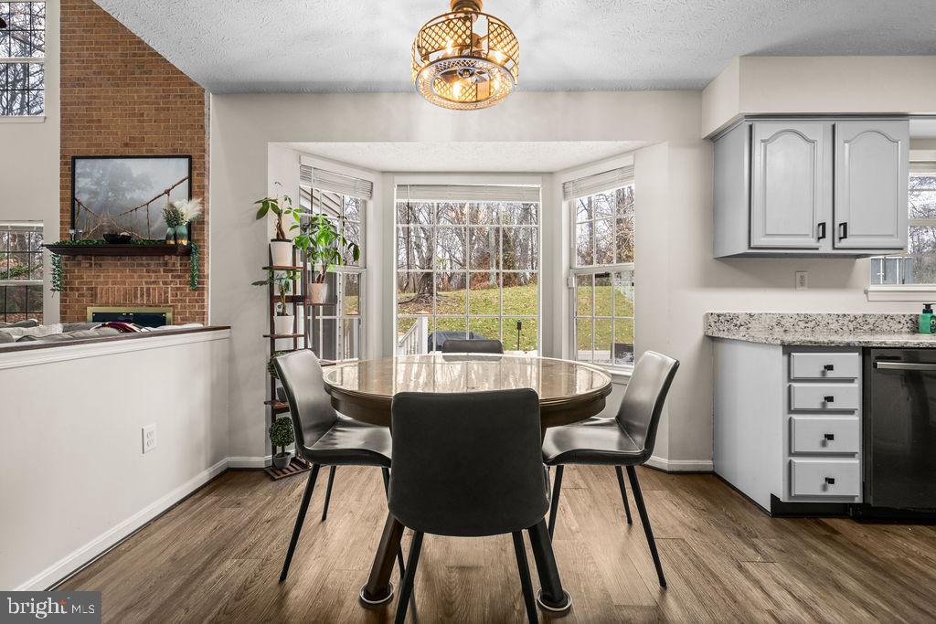 9803 Bald Hill Road Bowie, MD 20721 - Photo 16 of 55 a view of a dining room with furniture a chandelier and wooden floor