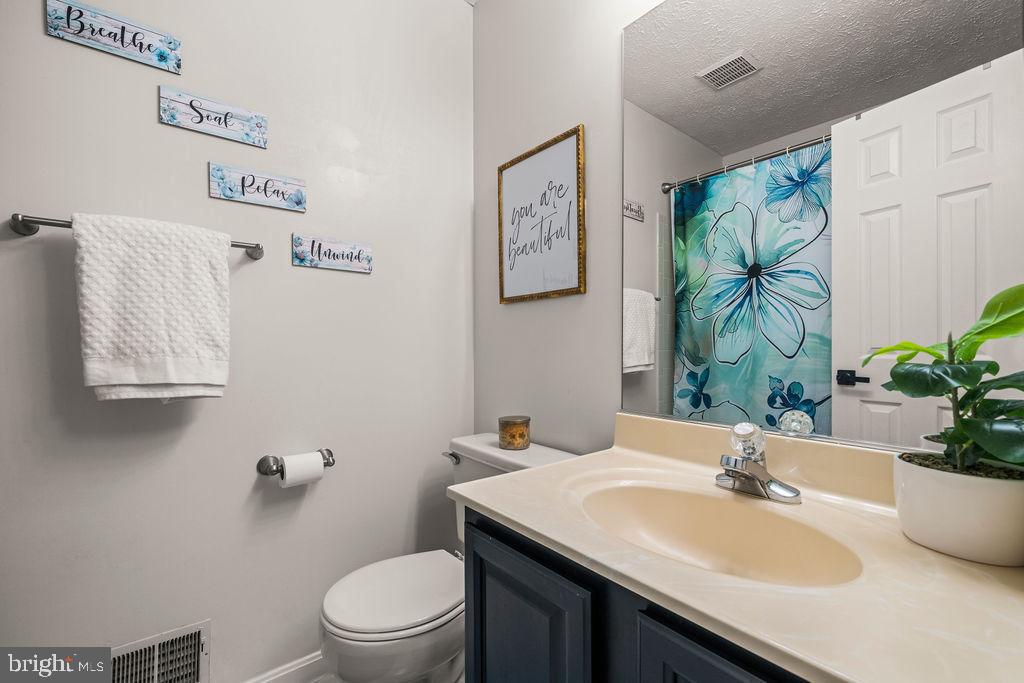 9803 Bald Hill Road Bowie, MD 20721 - Photo 28 of 55 a bathroom with a sink a toilet and a mirror