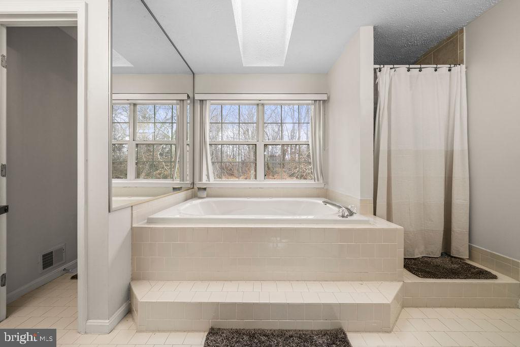 9803 Bald Hill Road Bowie, MD 20721 - Photo 34 of 55 a spacious bathroom with a bathtub and window