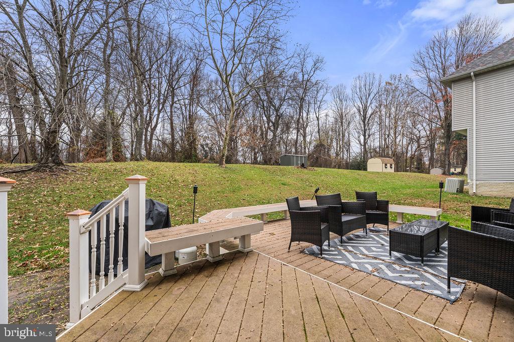 9803 Bald Hill Road Bowie, MD 20721 - Photo 49 of 55 a view of a wooden chairs and table on the wooden deck
