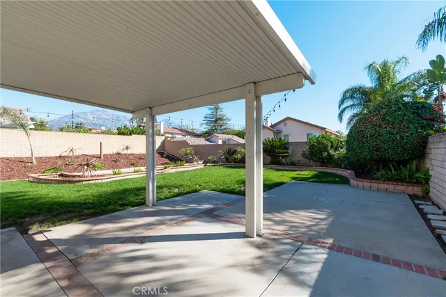 a view of a patio with table and chairs under an umbrella