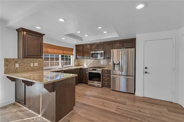 a kitchen with stainless steel appliances granite countertop a stove and a refrigerator