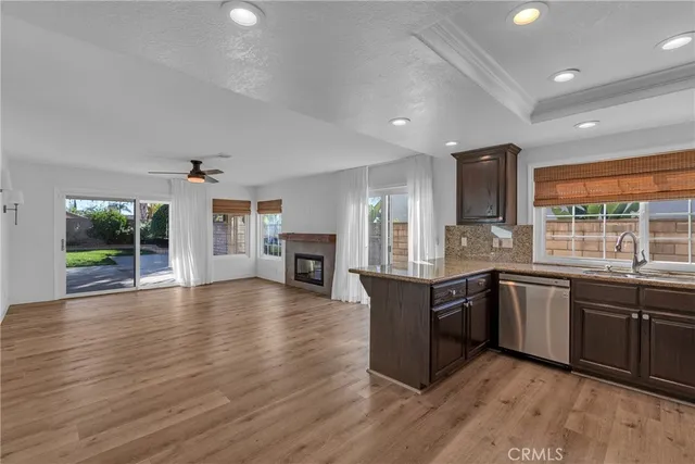 a large kitchen with wooden floors and stainless steel appliances