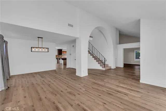 a view of empty room with wooden floor and stairs