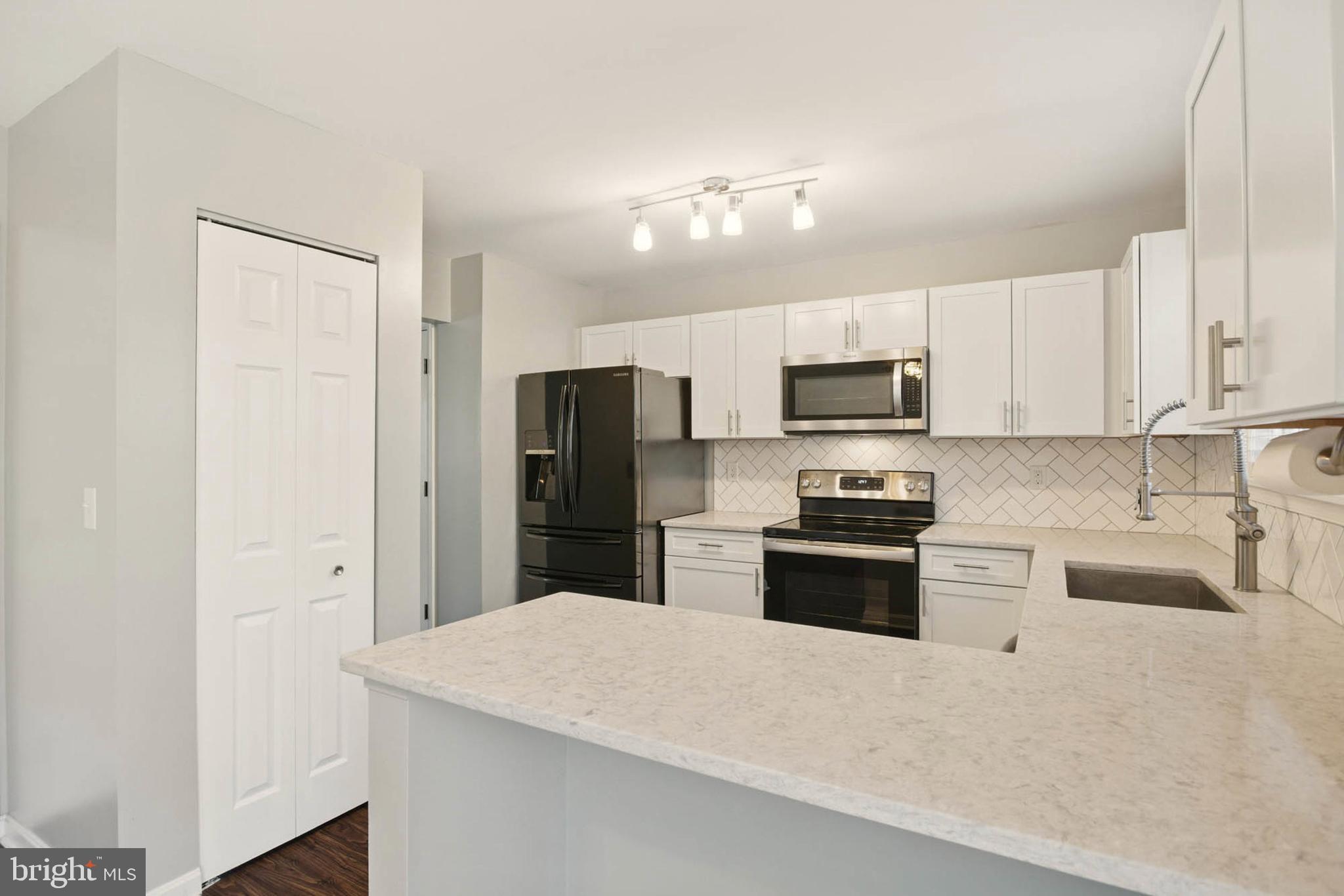 7812 Solari Court Pasadena, MD 21122 - Photo 4 of 30 a kitchen with stainless steel appliances a refrigerator stove microwave and sink