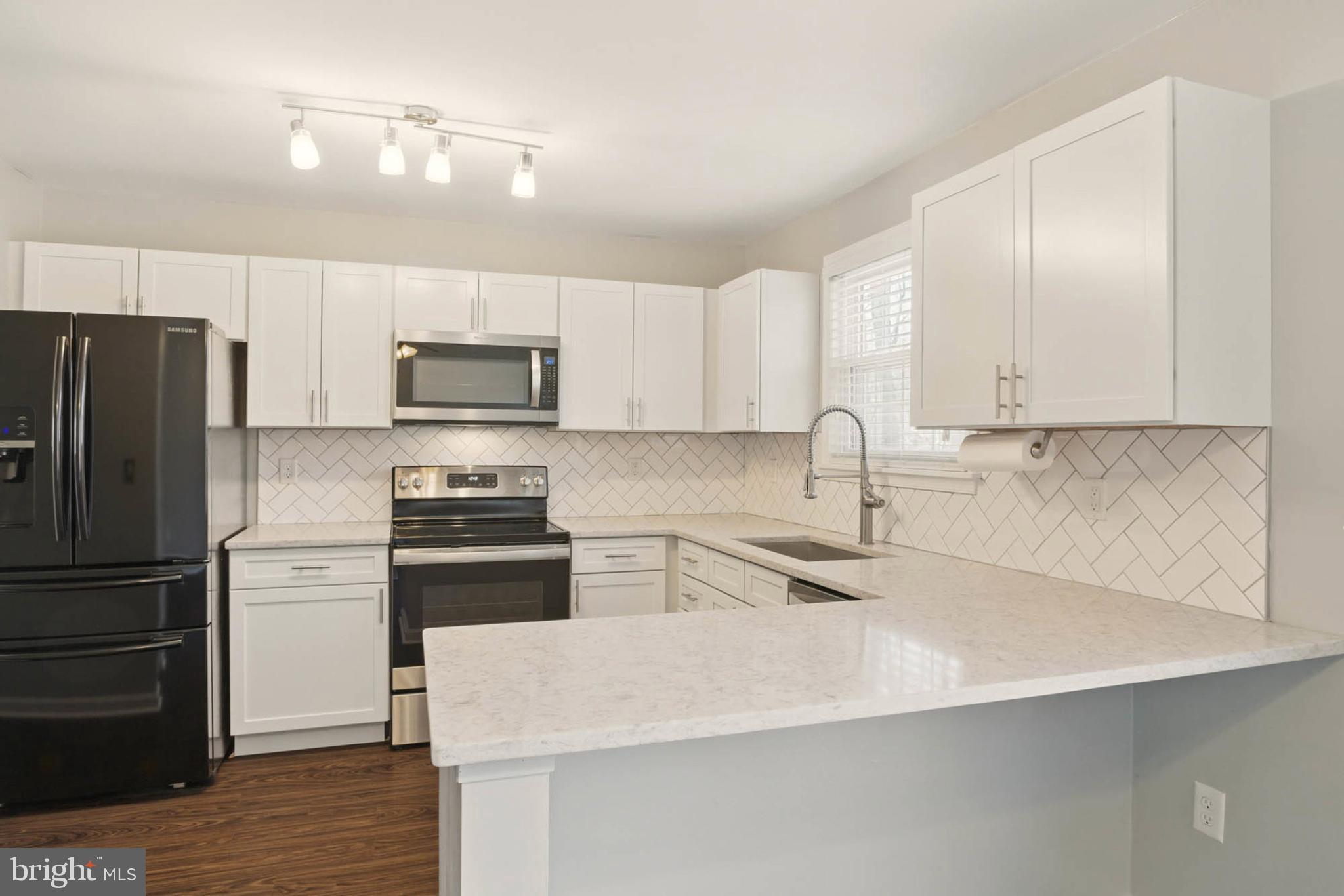 7812 Solari Court Pasadena, MD 21122 - Photo 5 of 30 a kitchen with stainless steel appliances a refrigerator sink and microwave