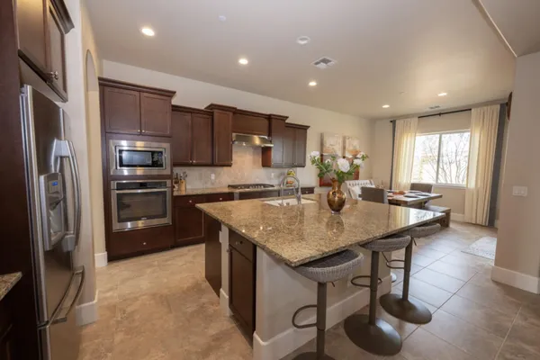 a living room with furniture and a flat screen tv with kitchen view