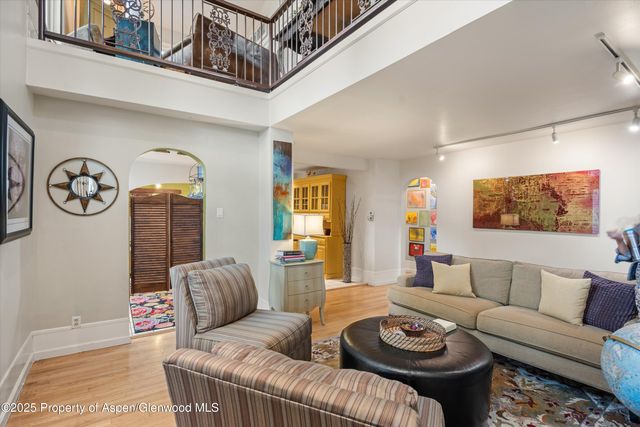 a living room with furniture a clock on wall and a window