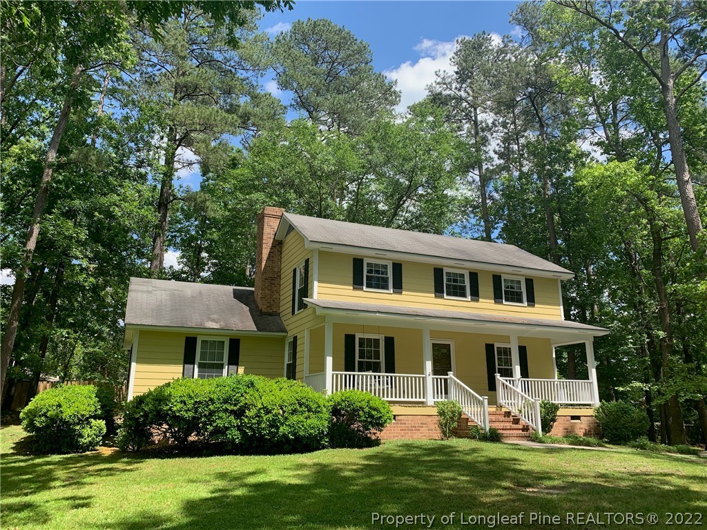 302 Old Farm Road Raeford, NC 28376 - Photo 3 of 36 a front view of a house with a garden and trees