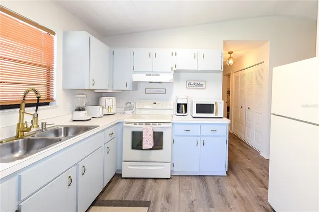 a kitchen with stainless steel appliances a white stove top oven sink and cabinets