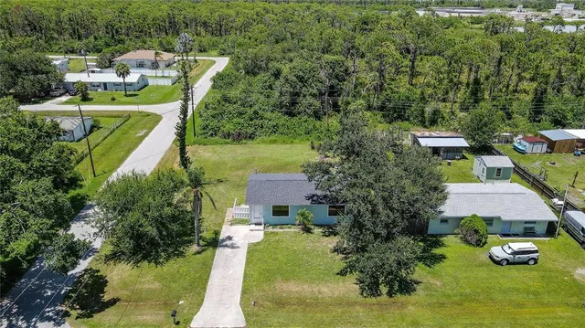 an aerial view of a house with a yard basket ball court and outdoor seating