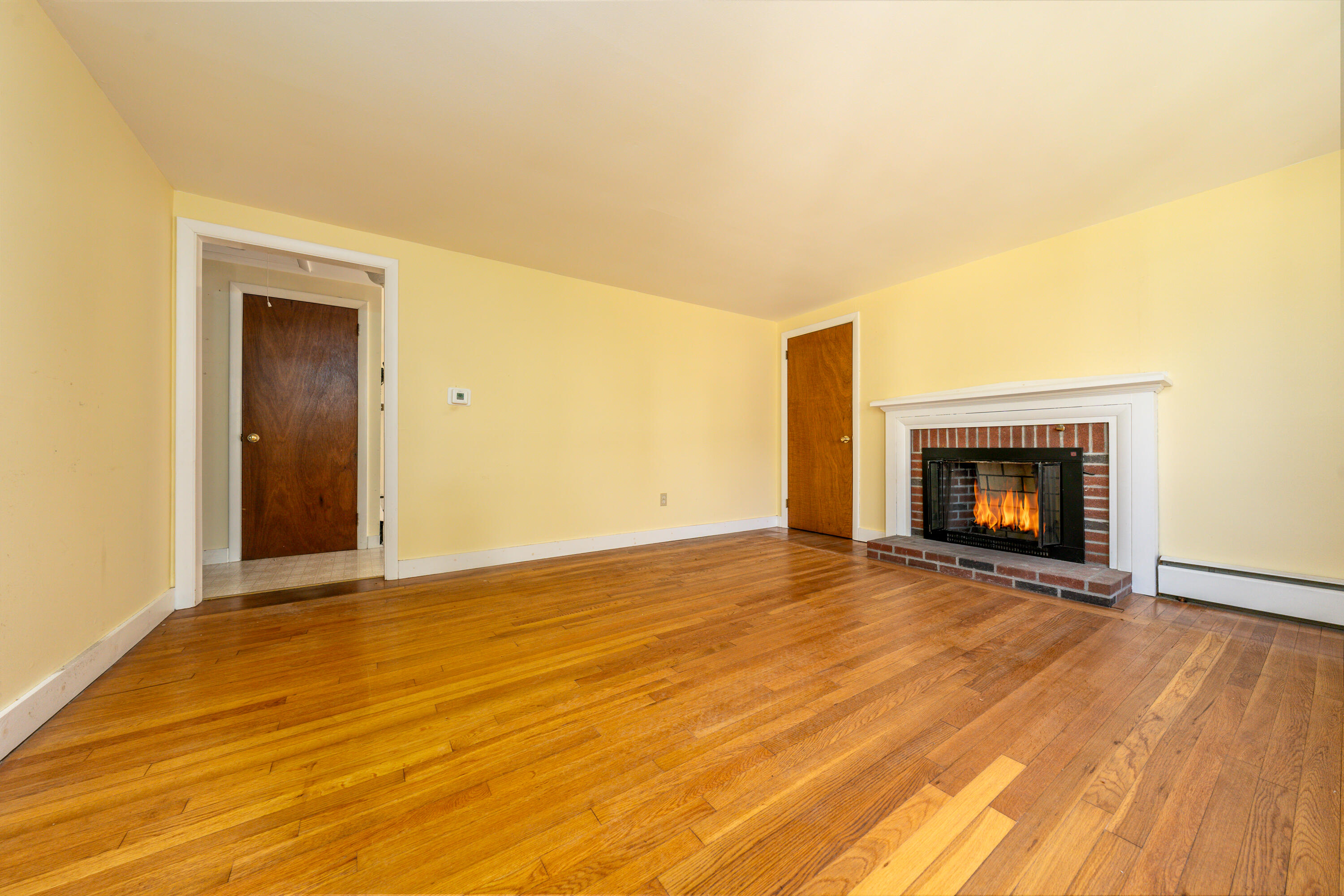 54 Hinckley Circle Osterville, MA 02655 - Photo 6 of 30 a view of an empty room with wooden floor and a fireplace