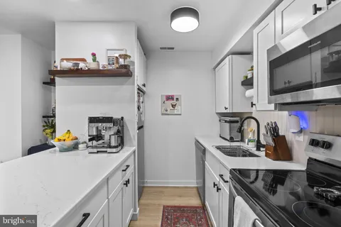 a kitchen with a sink a stove and cabinets