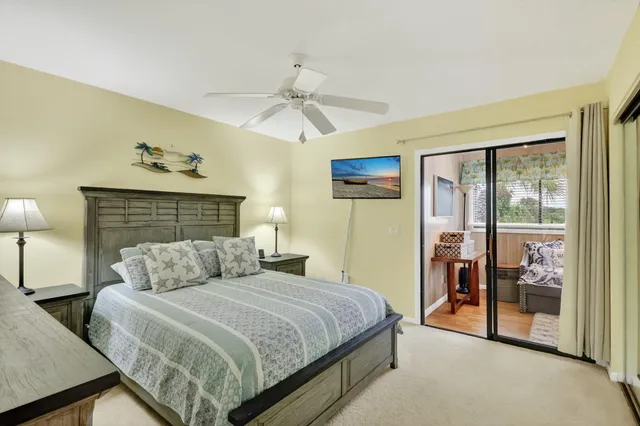a view of a white house with a big yard and potted plants