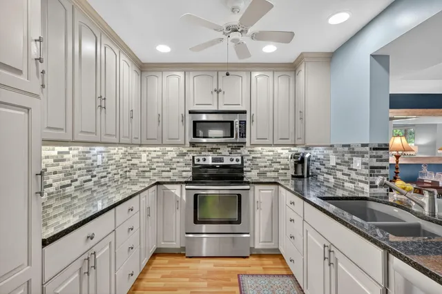 a view of a dining room with furniture a kitchen and chandelier